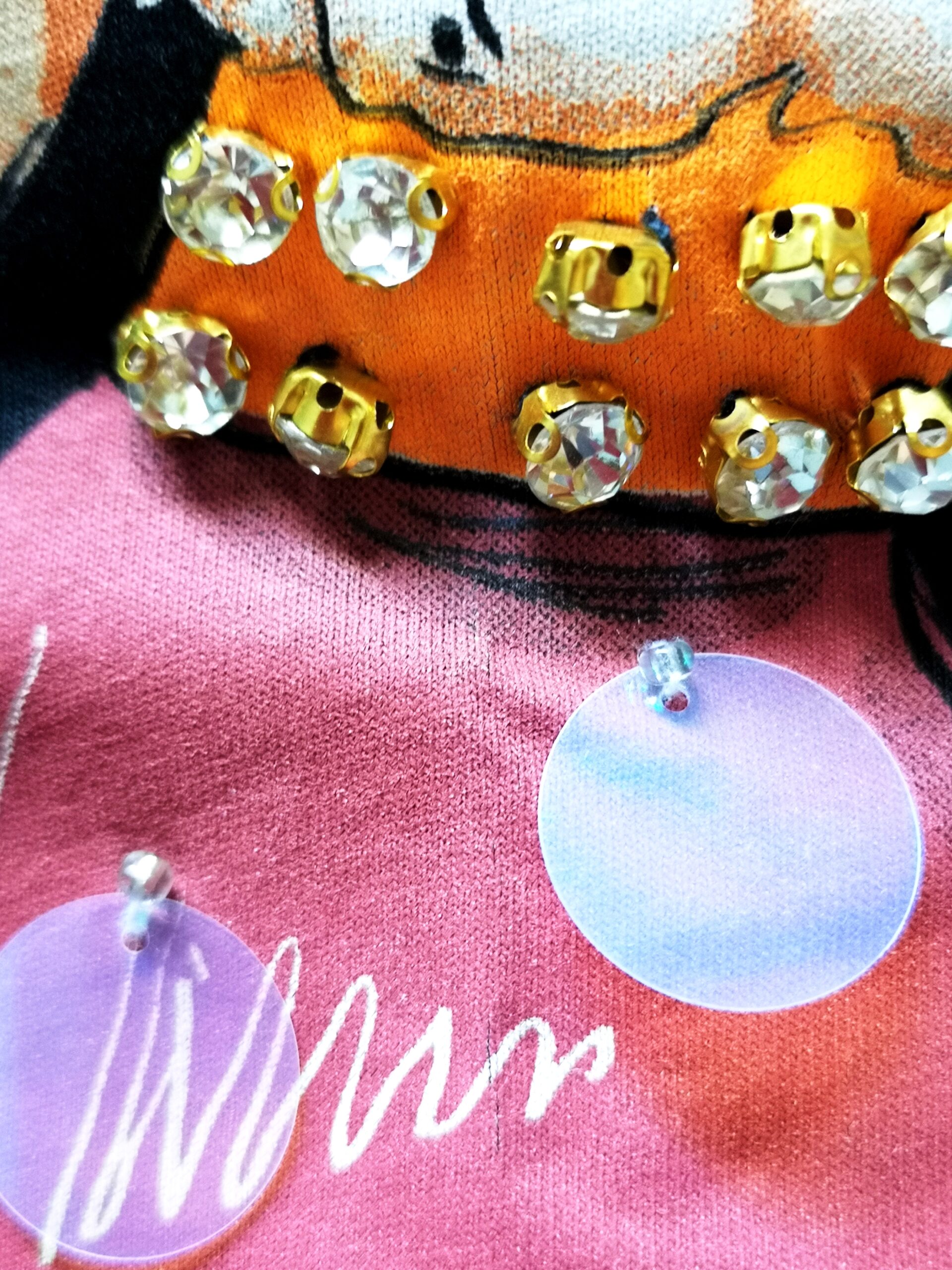 Jaunatviška trikotažinė palaidinė, kuri puošta įvairiomis blizgiomis detalėmis, akutėmis, plokštelėmis